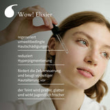 Junge Frau trägt eine Pipette vom Wow! Elixier auf Wange auf