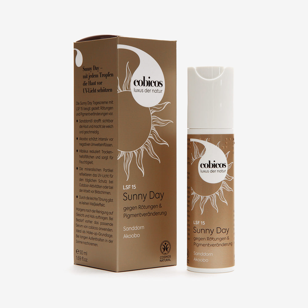 cobicos Sunny Day Cream mit LSF 15 beugt mit Sanddorn und Akoobo Rötungen und Pigmentveränderungen vor. Weißer Airless-Spender aus recyceltem OWP-Plastik. 50 ml mit goldener Umverpackung